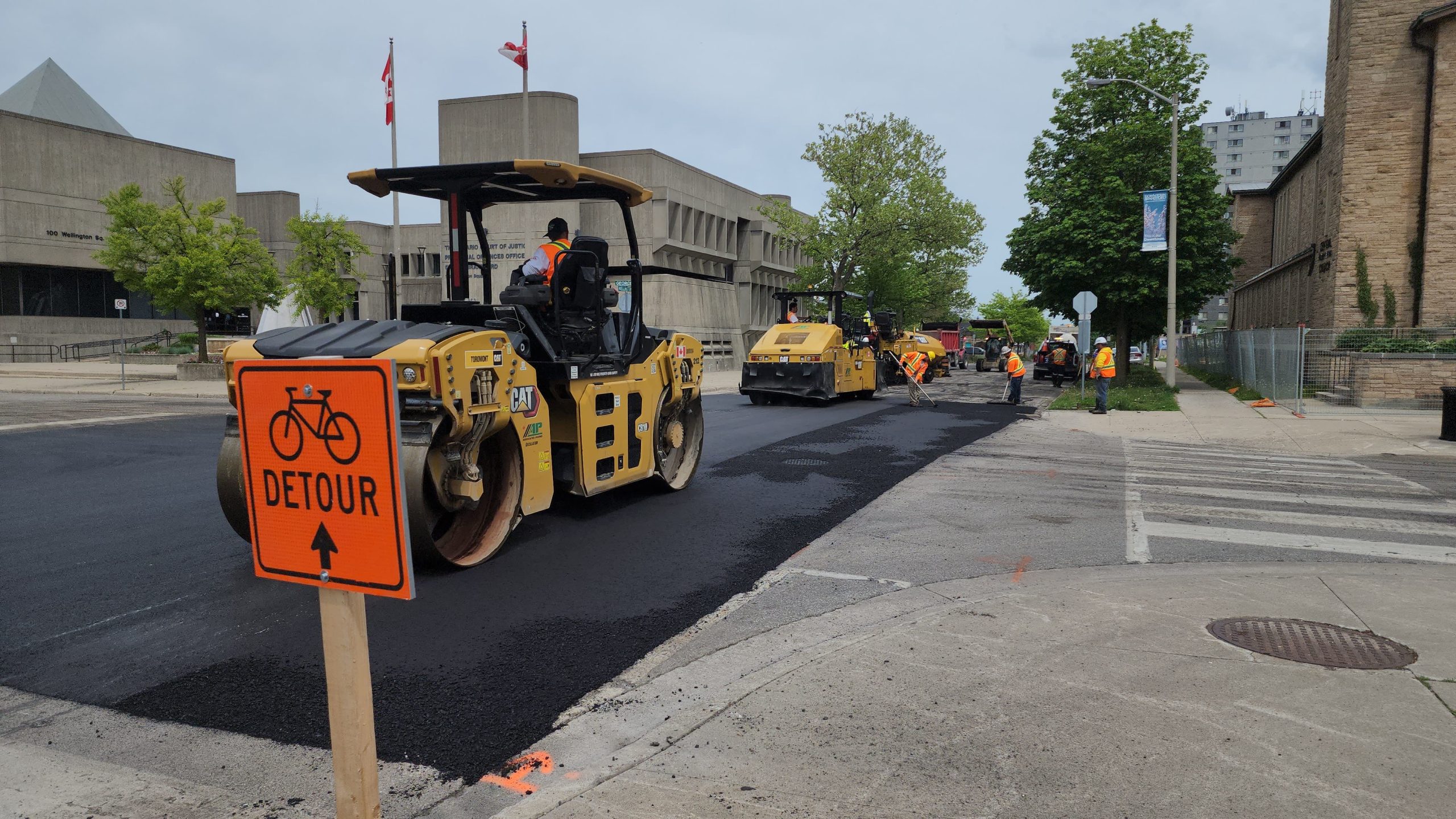 A road construction site with yellow machinery, workers, and a 